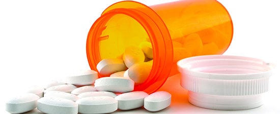 Prescription medication bottle with white tablets spilled out, relevant to discussions on medication side effects affecting foot and ankle conditions.