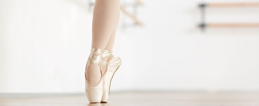 Ballet dancer en pointe showcasing foot positioning, relevant to discussions on foot health and conditions like Os Trigonum Syndrome.