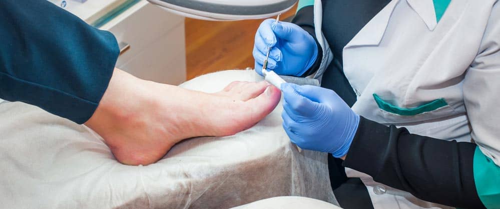 Podiatrist examining a patient's foot, providing foot care treatment, focusing on foot health and arch pain management.
