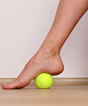 Foot exercise: Rubbing arch of foot over a tennis ball