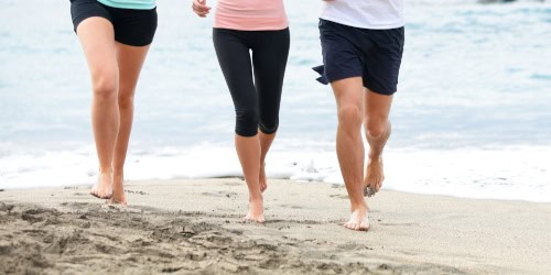 Barefoot runners on a beach, emphasizing natural running techniques and foot health, relevant to discussions on barefoot running safety and injury prevention.