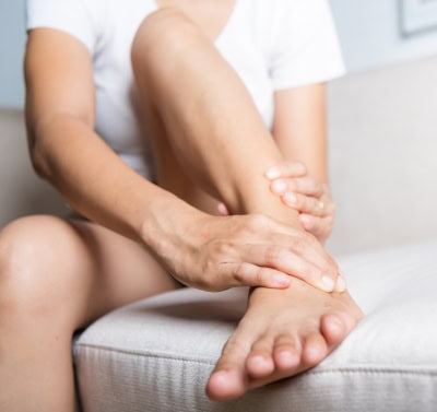 Woman holding ankle pain